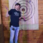 Photo of Tyler in an axe-throwing lane at a haunted house