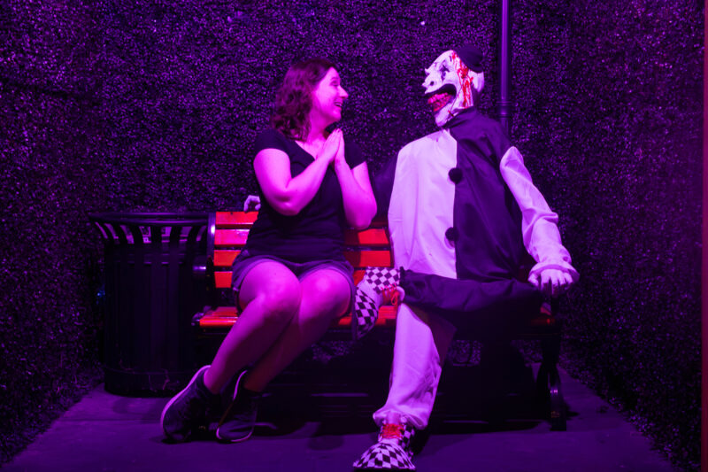 Woman sitting next to clown on bench